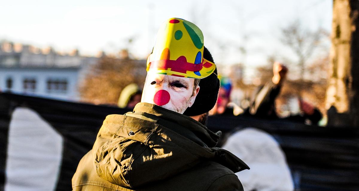 Supporters avec un masque de Roland Romeyer grimé en clown