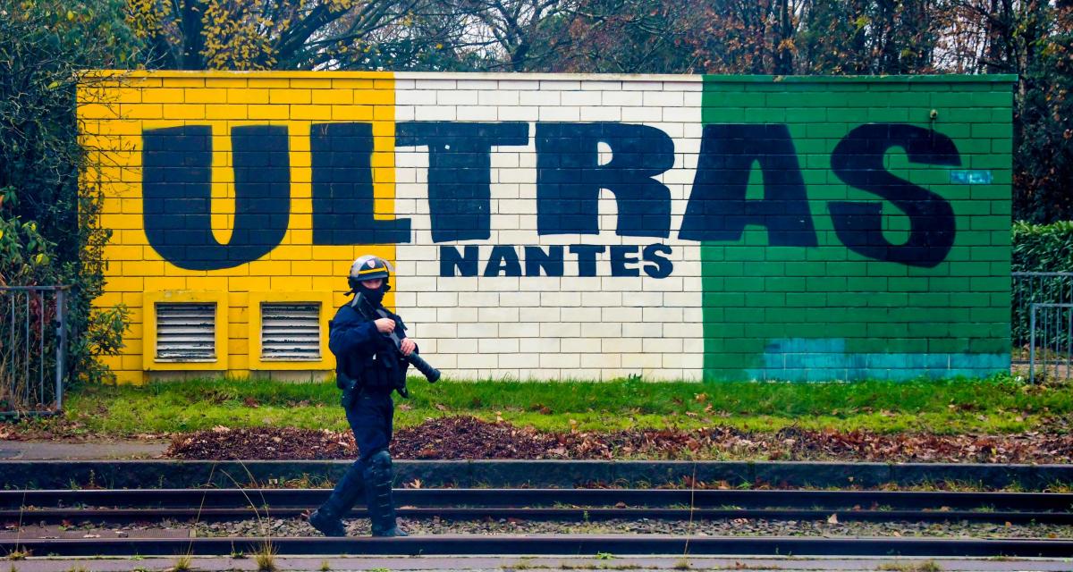 Policier devant un mur aux couleurs des ultras du FC Nantes